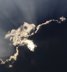 Des rayons de soleil grandement cachés par d'épais nuages.