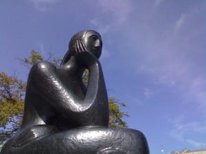 Statue d'une femme qui semble réfléchir.