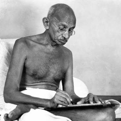 Gandhi écrit torse nu.