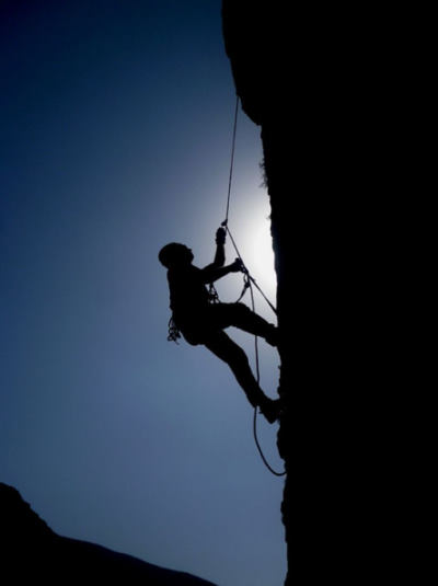 Un grimpeur escalade une falaise vertical.