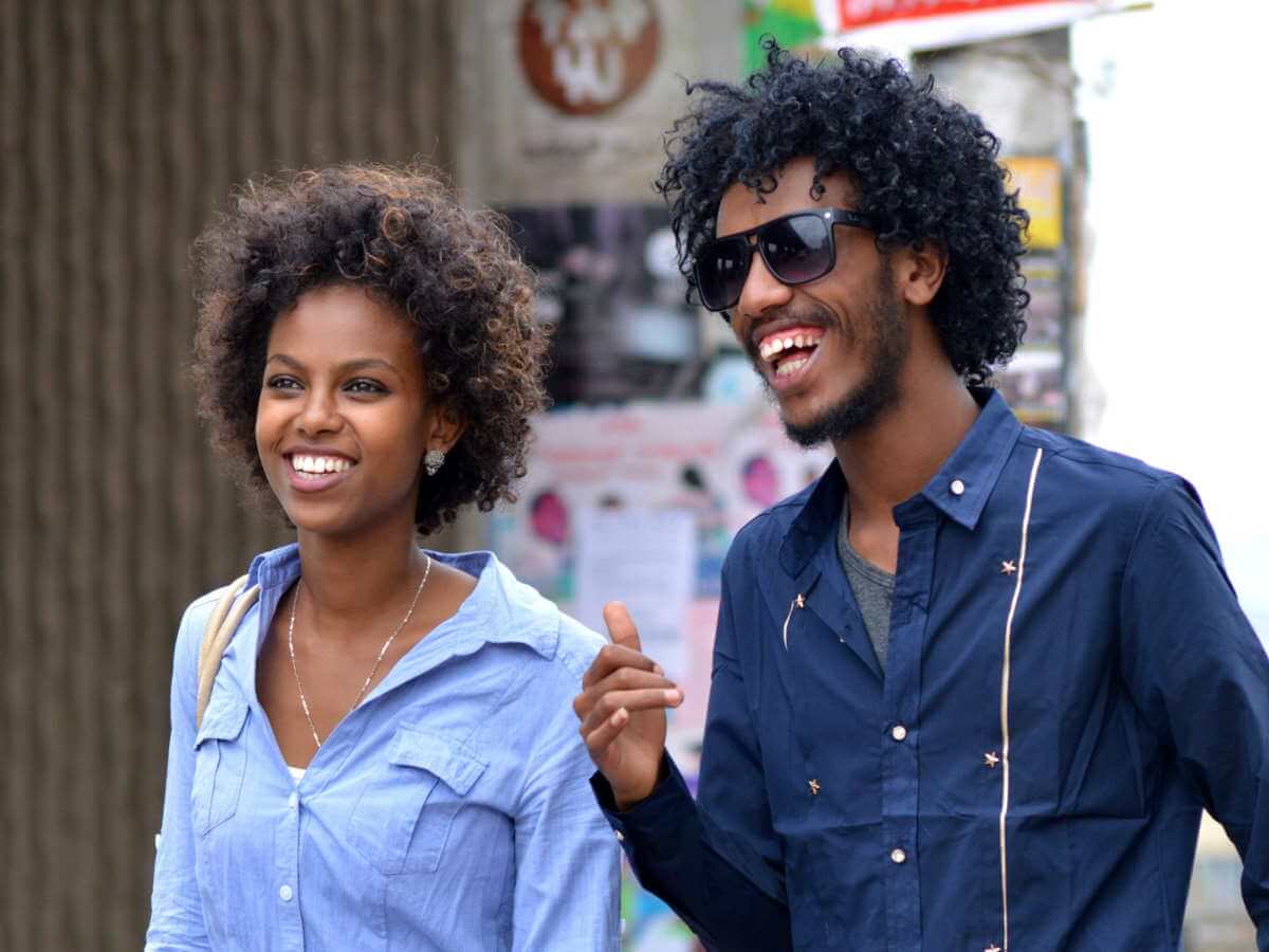 Couple souriant qui marche dans la rue.