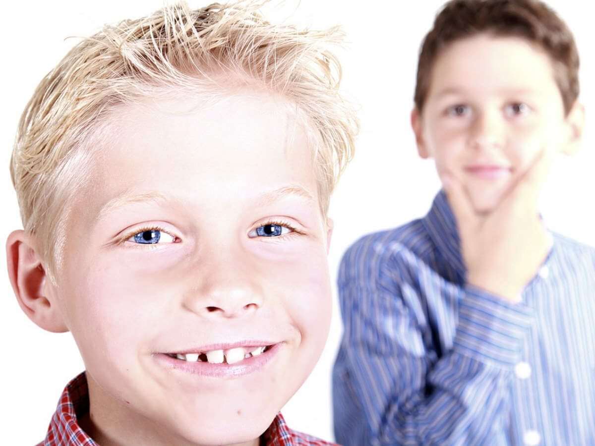 Un gamin regarde son frère souriant grandement.