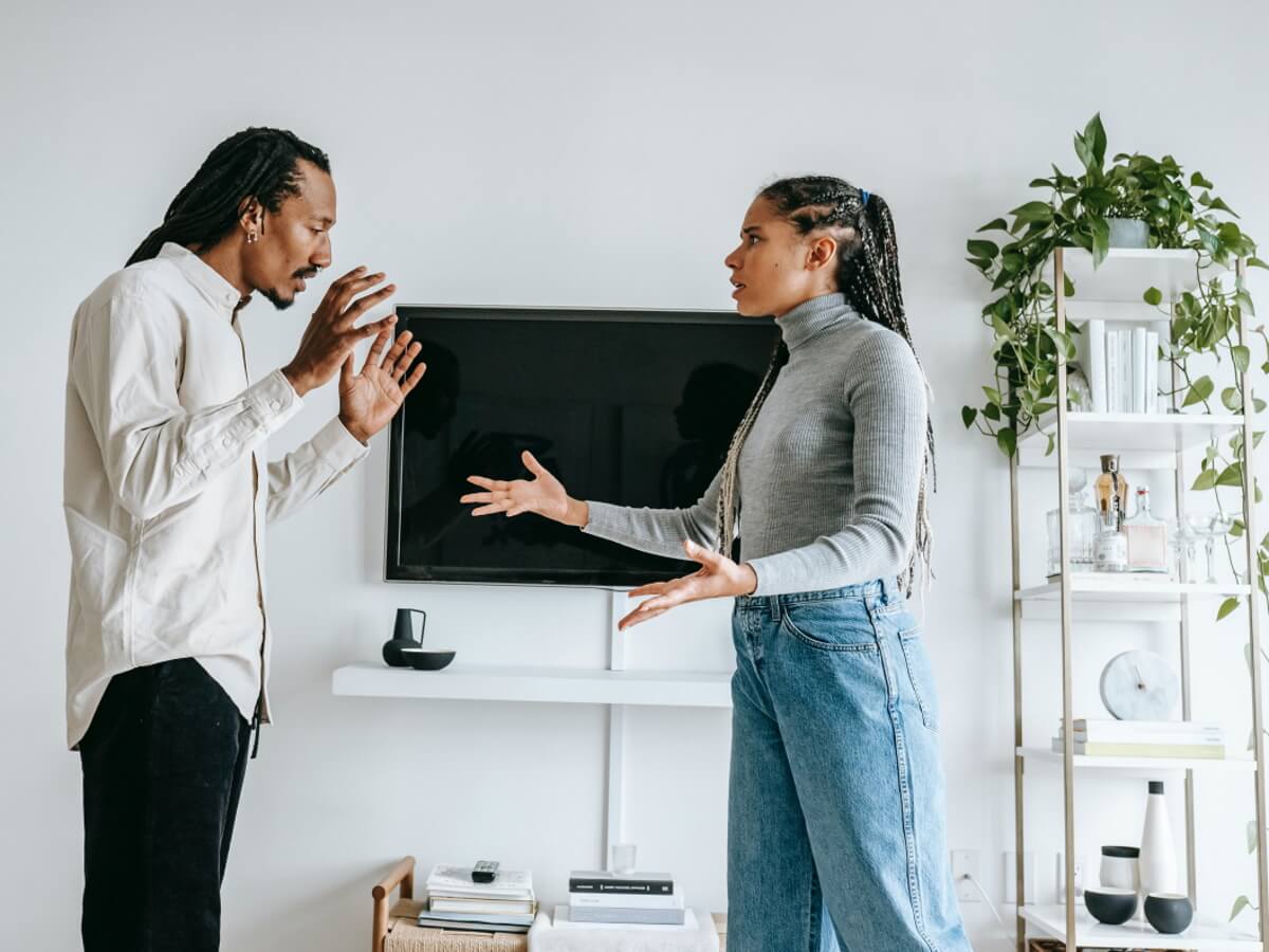 Un jeune couple se dispute, l'homme est en colère et parle à la femme.