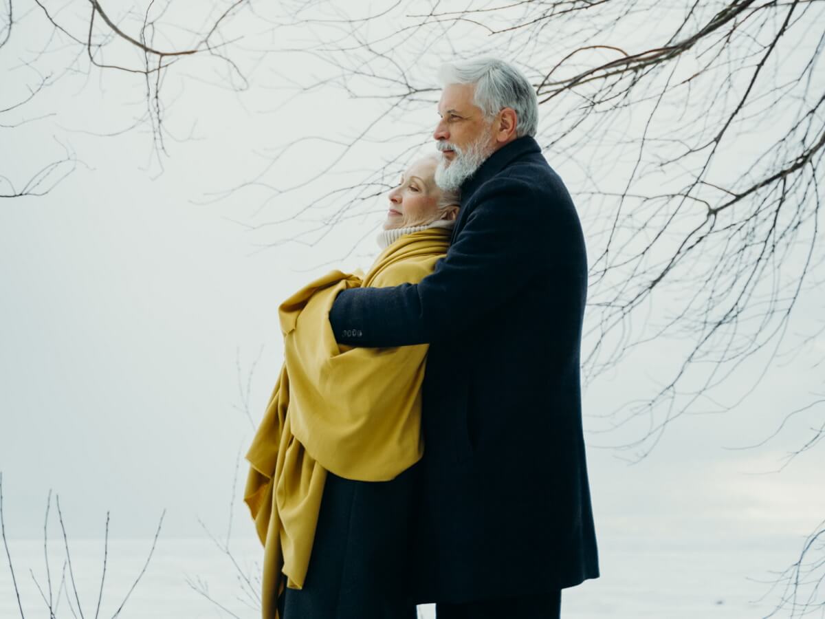 Un couple agé dans les bras l’un de l’autre.