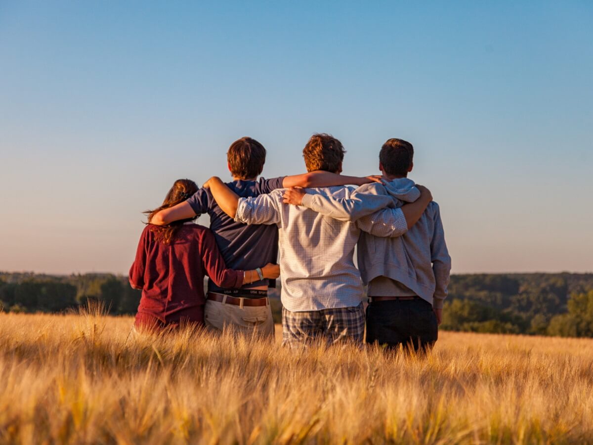 4 jeunes personnes enlassées dans un champ