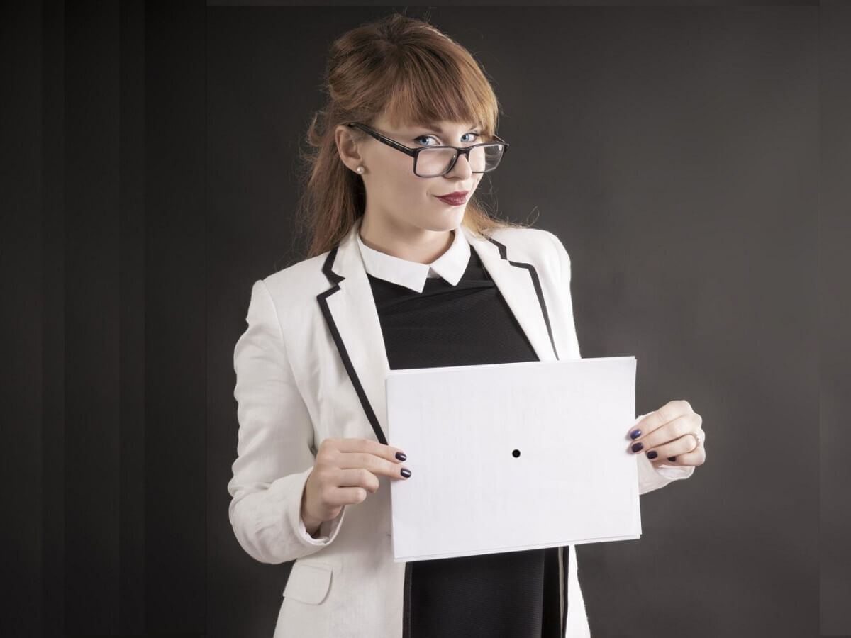 Une professeure tient une feuille presqu’entièrement blanche dans ses mains.