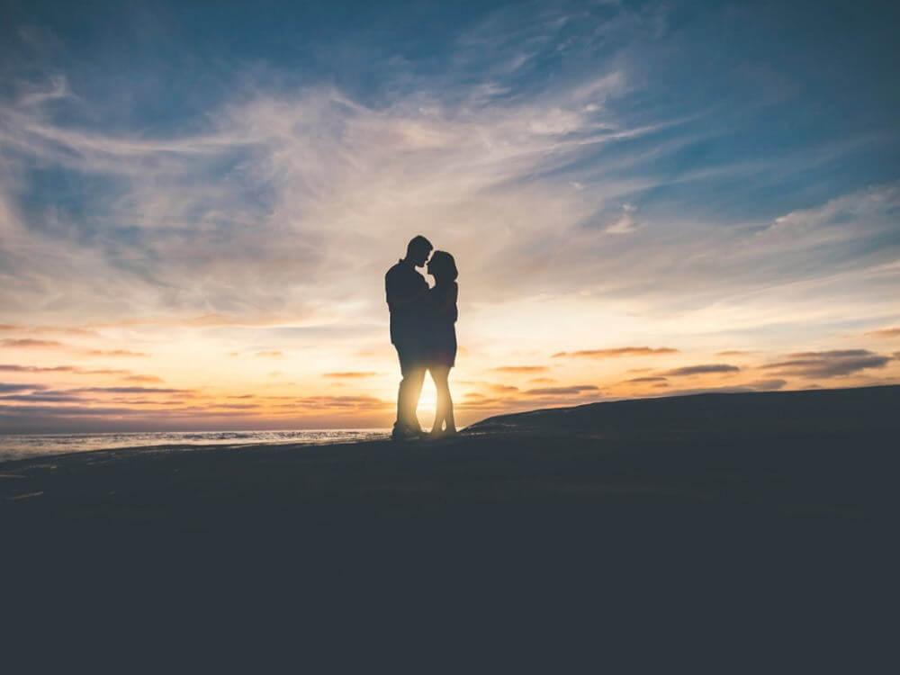 Silhouette d’un couple amoureux devant un coucher de soleil