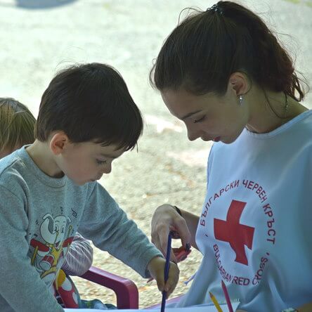 Une femme aide un enfant à dessiner.