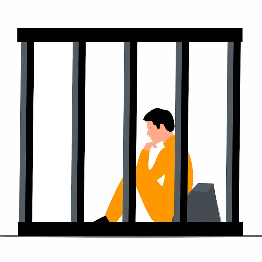 Un prisonnier assis dans sa cellule.