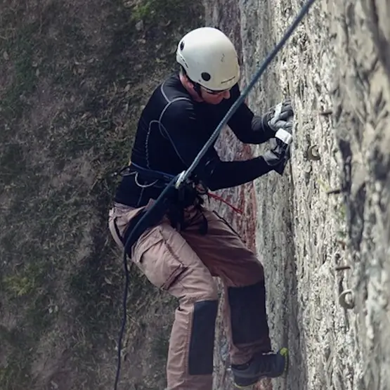 Un alpiniste grimpe sur une paroi verticale.