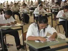 Des douzaines d'étudiants écrivent un examen.