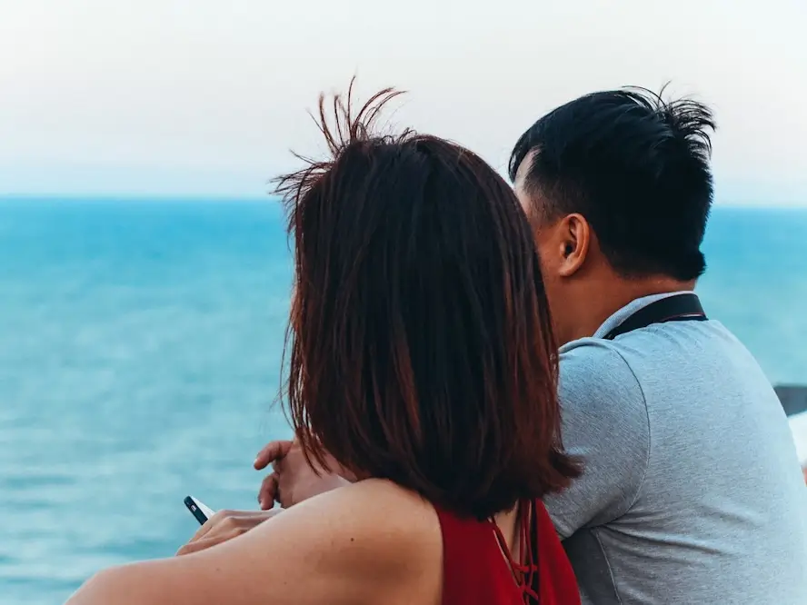 Un couple de dos regarde la mer.