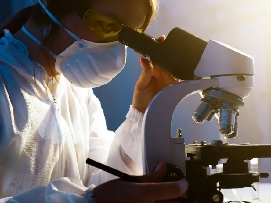 Une femme regarde dans un microscope.